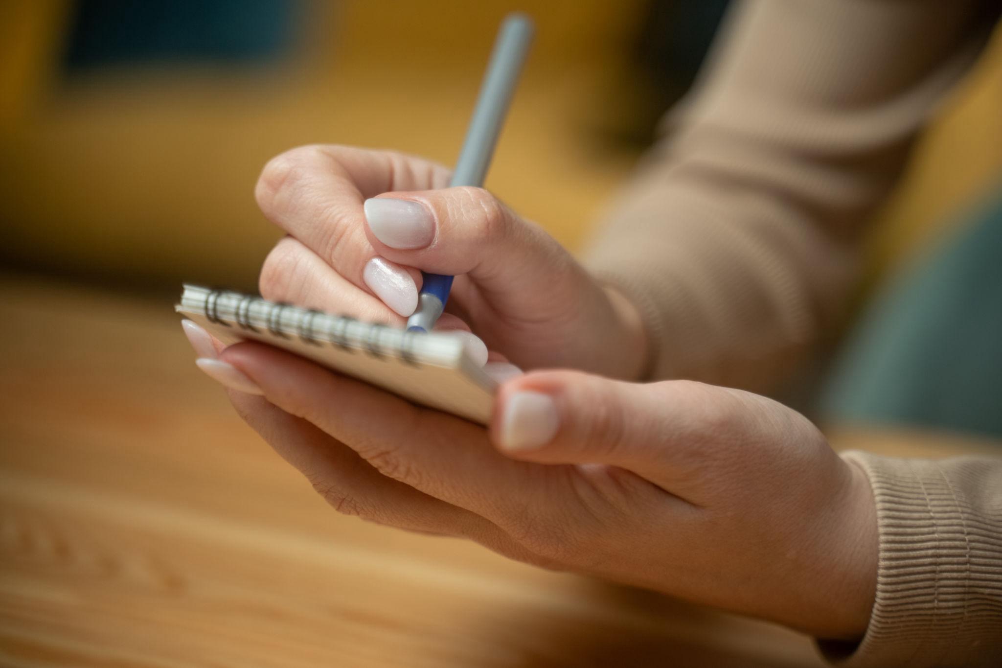 大事なことをメモにとっているイメージ画像