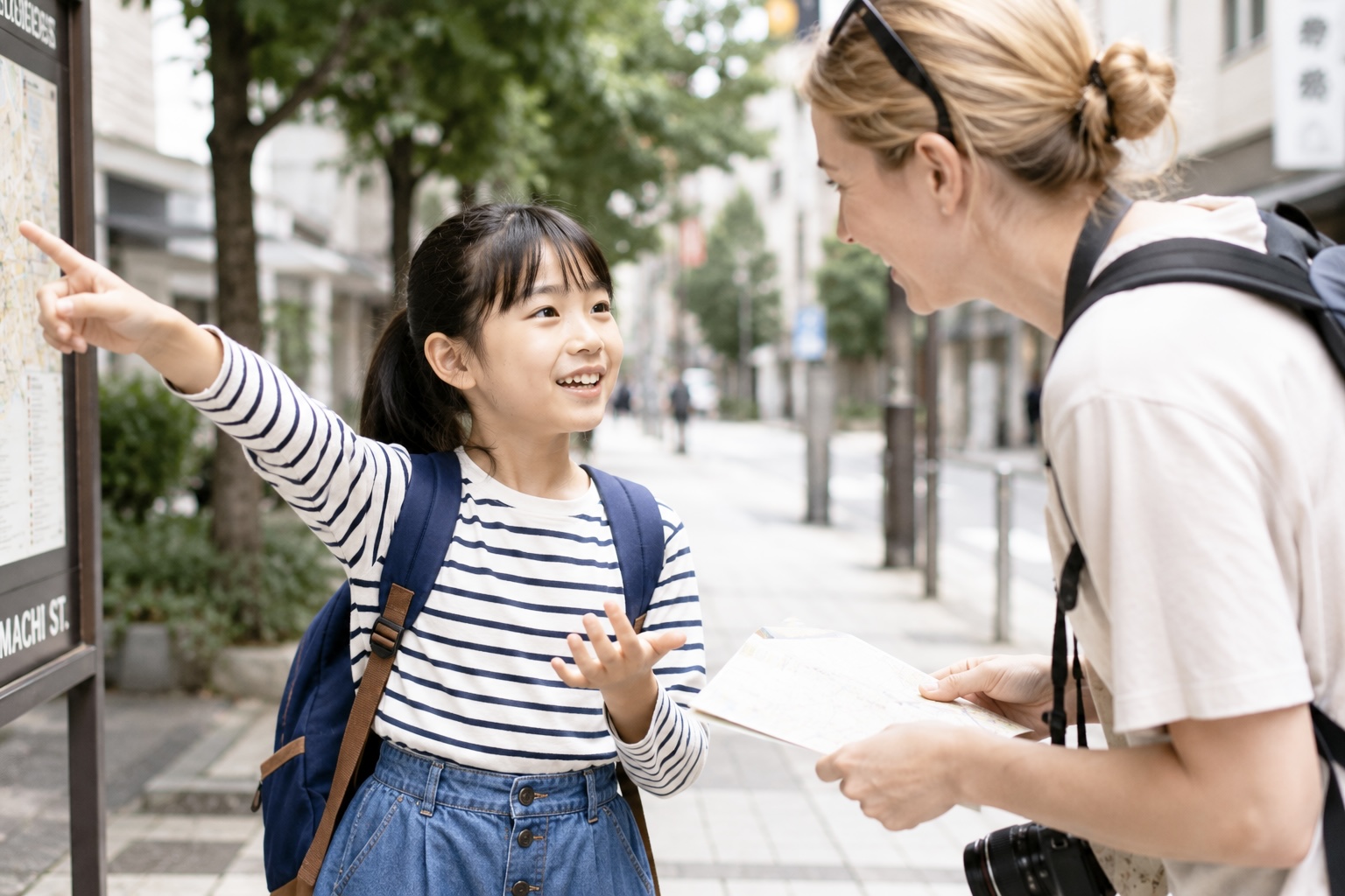 外国人観光客に道を聞かれた小学生が英語で道を説明しているイメージ画像